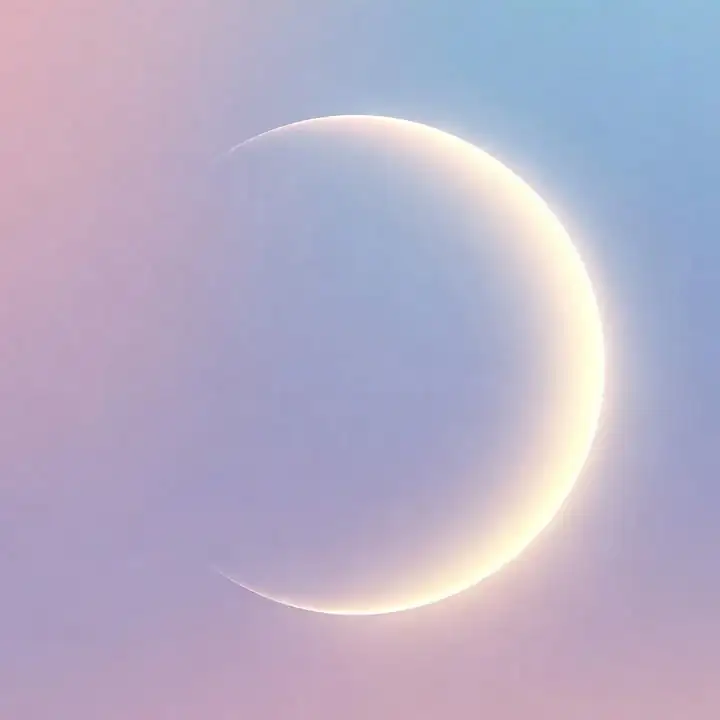 A thin crescent moon in a pastel pink sky