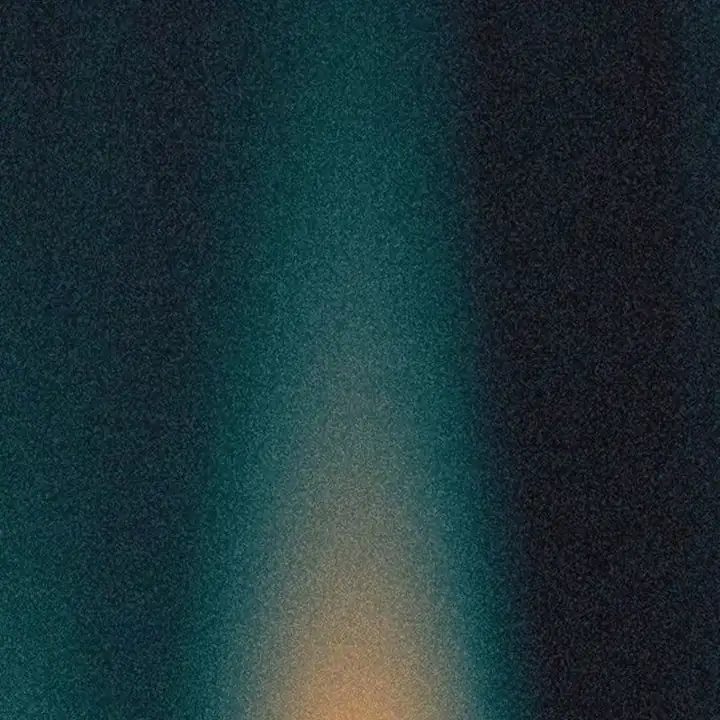 A dim green glow in a dark grainy field