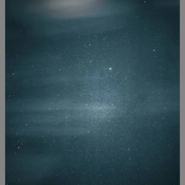 Speckled dust across a dark slate surface