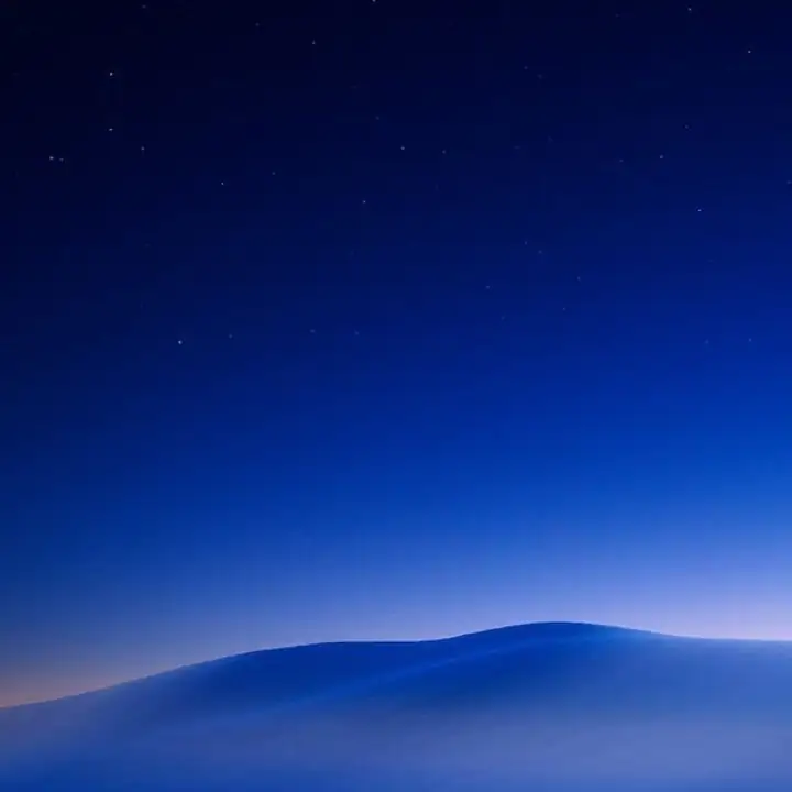 Low hills under a deep blue night sky