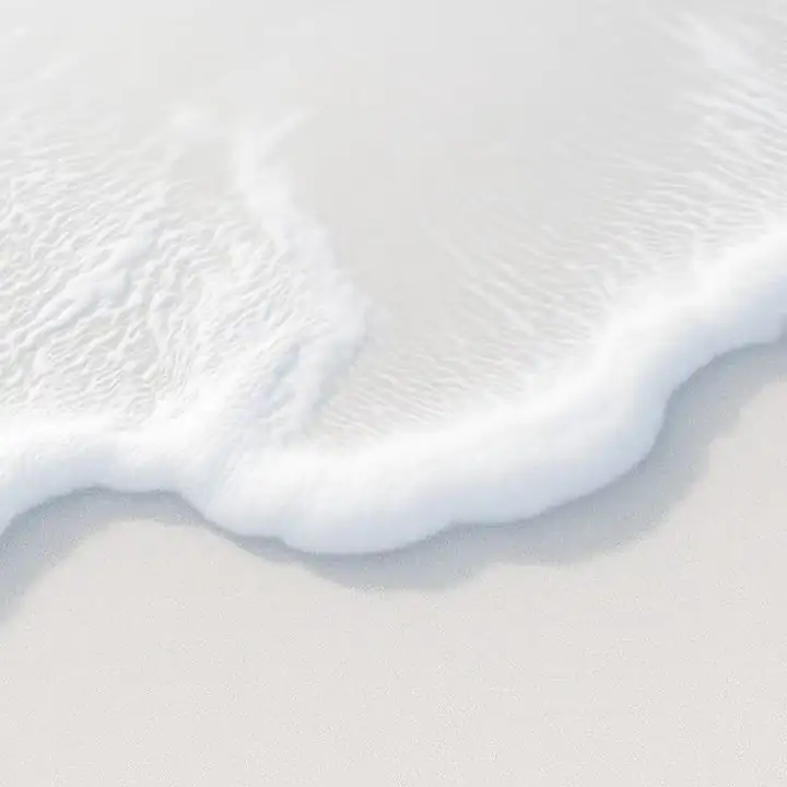 Foam meeting pale sand, seen from directly above