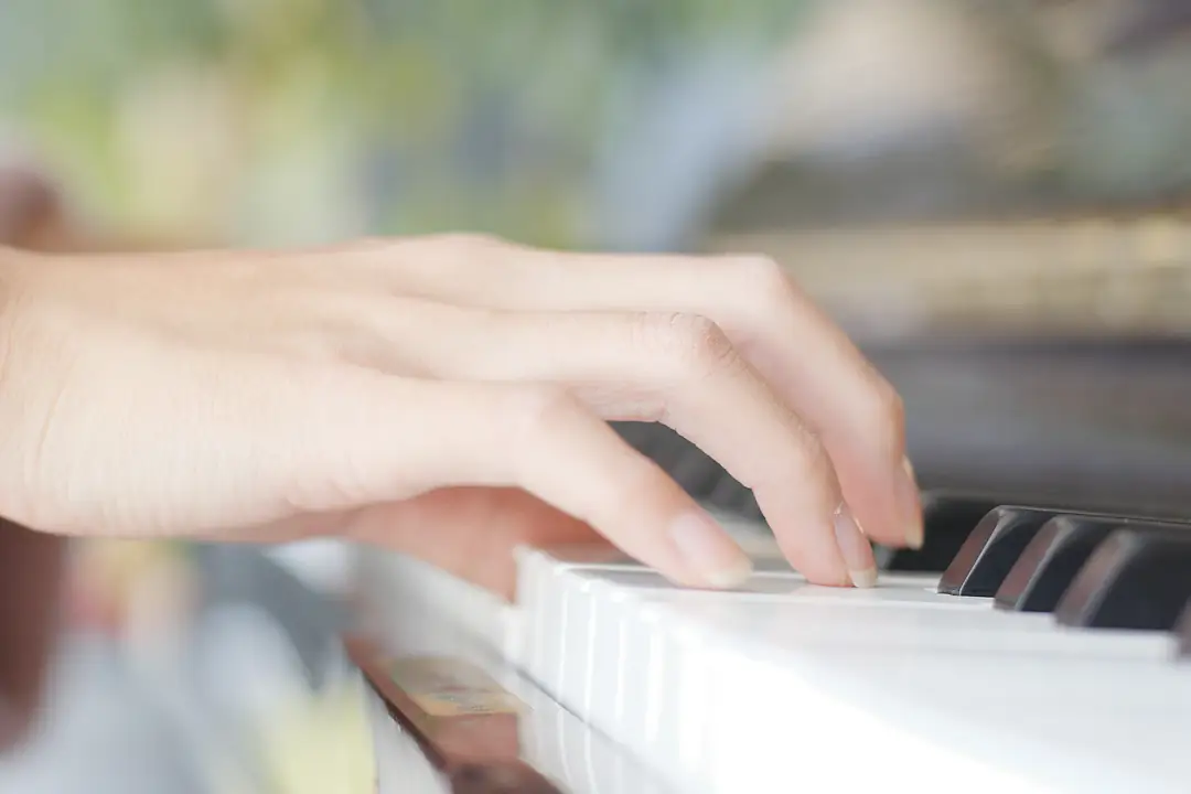 Hands practising on piano keys in soft daylight